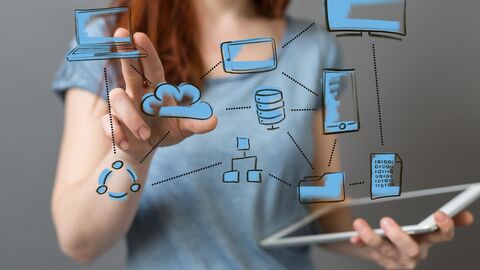 Eine Frau hält ein Tablet in der Hand uns zeigt auf verschiedene Symbole