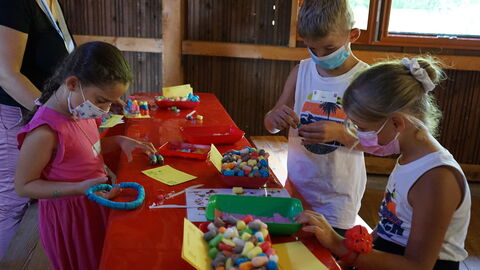 Mit bunten Elementen bastelnde Kinder beim Drillingstreffen 2021