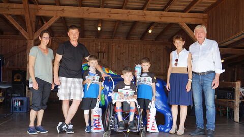 Volker Bouffier und seine Frau Ursula mit Eltern und Drillingen auf der Bühne beim Drillingstreffen 2021