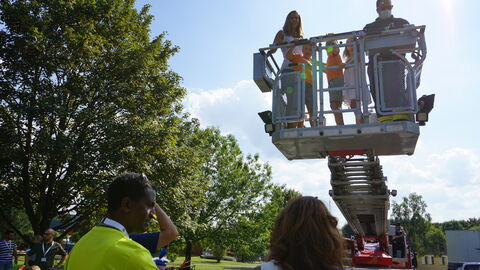 Spaß beim Drillingstreffen 2021: Eine Frau, ein Mann und drei Kinder werden mit einer Hebebühne mehrere Meter in die Höhe gehoben