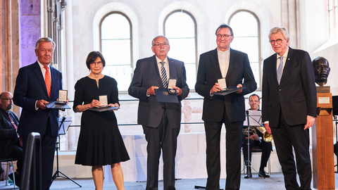 Verleihung der Wilhelm Leuschner-Medaille 2020 an Prof. Dr. Martin Hein, Norbert Kartmann, Andreas von Schoeler und Minka Pradelski   Die Preisträger der Wilhelm-Leuschner-Medaille stehen nebeneinander auf einer Bühne und schauen in die Kamera