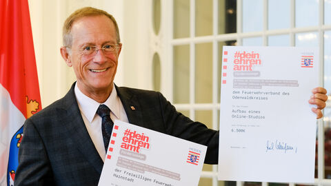 Staatsminister Axel Wintermeyer mit zwei Förderbescheiden