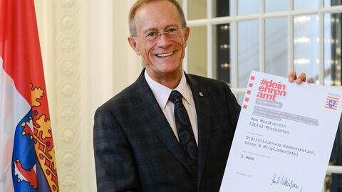 Staatsminister Axel Wintermeyer mit einer Förderurkunde