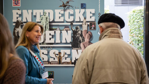 Zwei Personen im Gespräch vor einem Hessen-Plakat: Am Stand der HA Hessen Agentur drehte sich alles um das Gemeinschaftsprojekt "Kultur in Hessen"