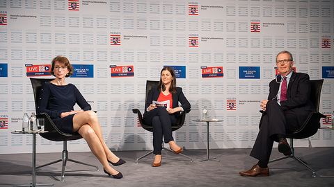 v.l.n.r. Prof. Dr. Indra Spiecker genannt Döhmann, Goethe-Universität Frankfurt am Main, Lucia Schulten, Deutsche Welle in Brüssel sowie der Europaabgeordnete Axel Voss sitzen während der Veranstaltung vor einer Motivwand und schauen in die Kamera