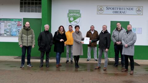Europaministerin Lucia Puttrich bei der Übergabe des Bescheides an den 1. Vorsitzenden der Sportfreunde Oberau 1951 e.V., Herrn Thomas Haas, und weiteren Mitgliedern des Sportvereins.