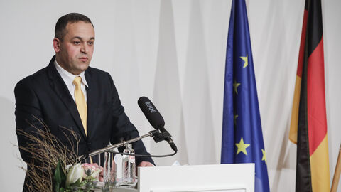 Am Rednerpult steht und spricht Radouan Bachiri, Initiator und Präsident des „International Women’s Leadership Forums“ 