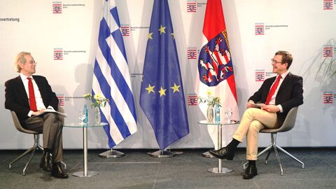 Im Gespräch vor einem Hintergrund mit Fahnen der Europäischen Union und Hessen: S. E. Prof. Dr. Andrzej Przyłębski und Christoph von Marschall 