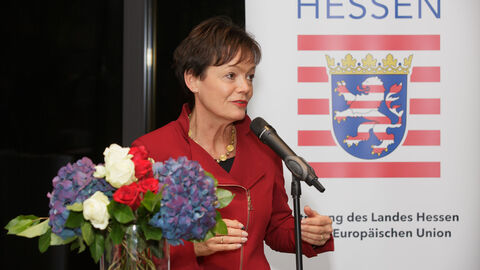 Ministerin Lucia Putrrich spricht bei der Veranstaltung Hessischer Jahresempfang in Luxemburg in ein Mikrofon zu den Teilnehmern