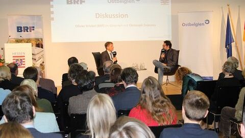 Veranstaltung Belgien am Scheideweg. Im Foto: Zuhörer der Veranstaltung schauen auf die Bühne, auf der die Teilnehmer miteinander im Gespräch sind