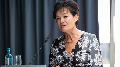 Lucia Puttrich steht am Rednerpult vor einem dunklen Vorhang auf der Bühne: Europaministerin Lucia Puttrich eröffnete die Foto-Ausstellung „Schlösser und Gärten im Fokus“ in der Hessischen Landesvertretung Berlin.