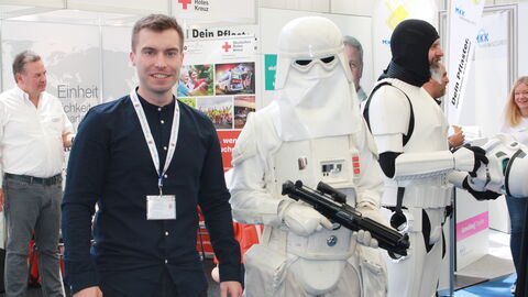 Ein Mitarbeiter der Landesregierung mit einem Roboter 