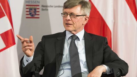 Moderator Ewald König spricht sitzend während der Veranstaltung mit den Diskussionsteilnehmern