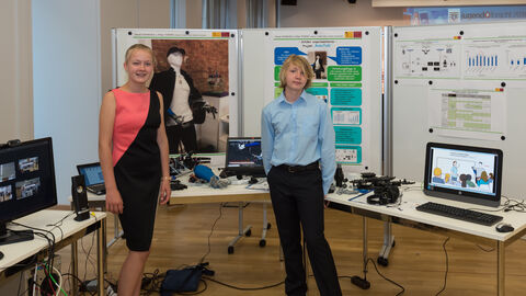 Zwei junge Erwachsene stehen vor Tischen mit Stellwänden dahinter. Auf den Tischen befinden sich verschiedene Gegenstände, wie Computerbildschirme und Tastaturen: Erstmalig war auch ein Projekt des Wettbewerbs „Schüler experimentieren“ aus Hessen mit dabei. Daniel Homburg (13) aus Darmstadt und Mirja Sophie Thieme (13) aus Erzhausen stellten den von ihnen entwickelten Gebärdensprachenroboter vor.