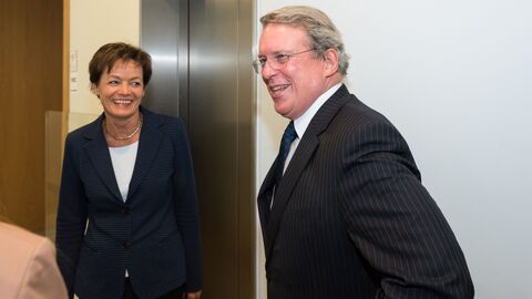 Ein Mann und eine Frau stehen in einem Flur vor einem Aufzug und lachen: Ministerin Puttrich mit Botschafter Kelleher, Ständiger Vertreter Irlands bei der EU 