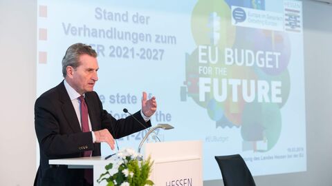 Ein Mann im dunklen Anzug steht vor einer Leinwand und präsentiert etwas: EU-Haushaltskommissar Günther H. Oettinger erläutert den Stand der Verhandlungen zum MFR 2021-2027