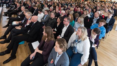 Viele Menschen sitzen in Stuhlreihen, in eine Richtung blickend, nebeneinander in einem Raum: Über 350 Gäste waren der Einladung in die Hessische Landesvertretung gefolgt