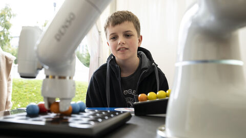 Ein kleiner Junge betrachtet einen Roboterarm bei Tätigkeiten: …Wie macht der das nur?... (Der Digit-Truck hat begeistert!)