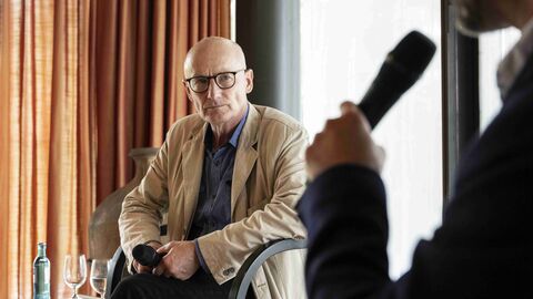 Im Interview: Der Zeitzeuge Ekkehard Maaß, Liedermacher, Publizist und Übersetzer, sitzt auf der Bühne und spricht zu den Gästen