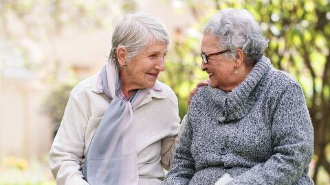 Zwei Frauen höheren Alters unterhalten sich sitzend  Zwei Frauen höheren Alters unterhalten sich sitzend