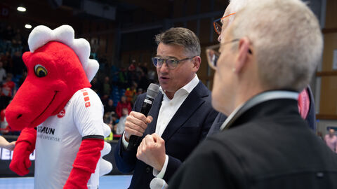 Ministerpräsident Boris Rhein steht auf dem Spielfeld der MT Melsungen und hält eine Rede