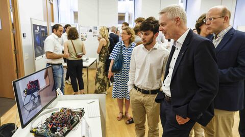 Interessanter Rundgang Personen betrachten eines der Projekte mit vielen Elektro-Kabeln auf einem Tisch