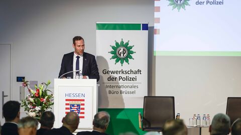 Ein Mann steht am Rednerpult, spricht zu den Gästen