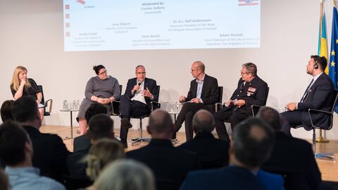 Es diskutierte ein hochrangiges Panel Personen auf dem Podium sprechen miteinander während der Podiumsdiskussion