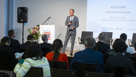 Begrüßung: Staatsminister Axel Wintermeyer spricht auf der Bühne zum Publikum