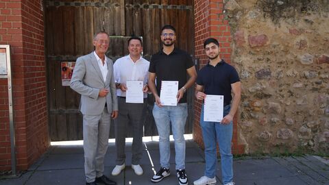 Staatsminister Axel Wintermeyer mit den beiden Sport-Coaches Ayaz Moustafa und Mohamad Rihawi sowie dem Bürgermeister der Stadt Hofheim, Christian Vogt, vorm Haus der Jugend, das im Wasserschloss angesiedelt ist (v.l.n.r.: Wintermeyer, Vogt, Moustafa, Rihawi).