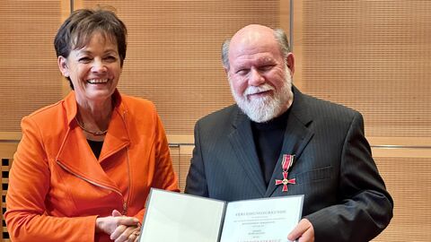 Europaministerin Puttrich mit Bodo Kester. Die beiden stehen nebeneinander und halten die Urkunde in Händen.