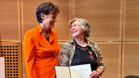 Europaministerin Puttrich neben Prof. Dr. Erika Baum. Sie halten gemeinsam eine Urkunde in Händen