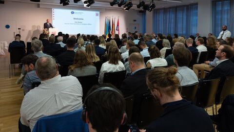 Uwe Becker steht auf der Bühne und spricht zum Publikum