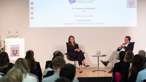 Natalie Amiri mit Dr. Thomas Gutschker im Gespräch. Sie sitzen sich gegenüber.