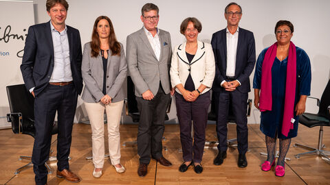 Gruppenfoto vom Panel. Insgesamt lächeln 6 Personen in die Kamera und stehen nebeneinander