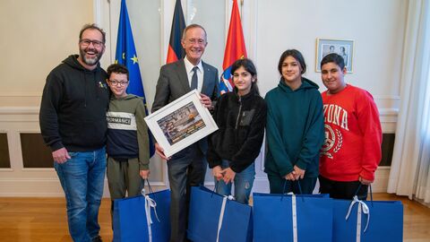 Kinder sowie Staatsminister Axel Wintermeyer und Daniel Schröder, Regionalleiter des Kinderprojektes Arche, lächeln in die Kamera.