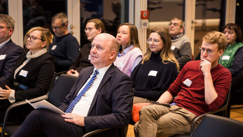 Eine Aufnahme des sitzenden Publikums zeigt Europastaatssekretär Uwe Becker und weitere Mitglieder des Europanetzwerks.