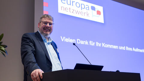 Daniel Baumgärtner, Referatsleiter der Hessischen Landeszentrale für Politische Bildung, erläutert die Aktivitäten seiner Institution anlässlich der Europawahl Daniel Baumgärtner steht am Rednerpult, im Hintergrund ist eine Präsentation zu sehen