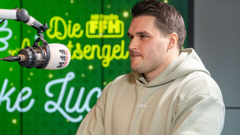 Luca Pasqualotto sitzt vor einem Mikrofon in einem Studio