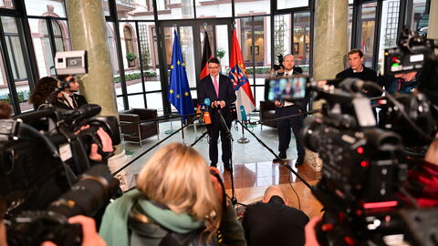 Pressestatement von Ministerpräsident Rhein nach seiner Wiederwahl Ministerpräsident Rhein bei seinem Pressestatement nach seiner Wiederwahl, umringt von unter anderem Mikrofonen und Kameras
