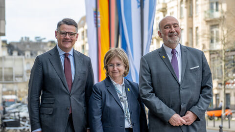 Boris Rhein, Talya Lador-Fresher und Ron Prosor stehen vor Flaggen