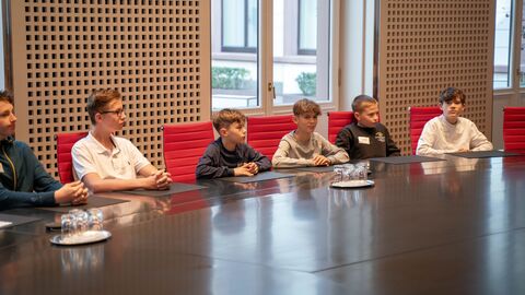 Schülerinnen und Schüler sitzen an einem großen Tisch