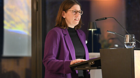 Die Dienststellenleiterin der Landesvertretung, Dr. Katharina Brauer, begrüßte das Publikum Frau spicht auf der Bühne: Die Dienststellenleiterin der Landesvertretung, Dr. Katharina Brauer, begrüßte das Publikum