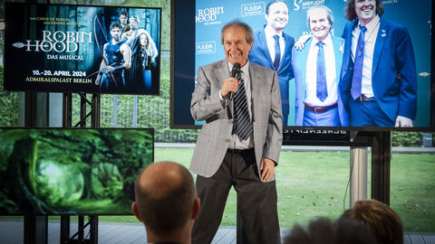 Chris de Burgh mit Mikrofon auf der Bühne: Kurz klang sein Lied „The Lady in Red“ an – Chris de Burgh: ein Weltstar auf der Bühne in der Hessischen Landesvertretung Berlin.