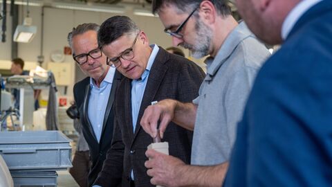 Ministerpräsident Boris Rhein und Prof. Bernd Kracke lassen sich die Arbeit in der Höchster Porzellanmanufaktur zeigen.