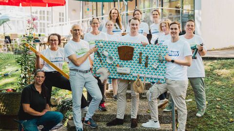 Staatskanzleichef Kuhn und Mitarbeitende der Hessischen Staatskanzlei halten ein selbst gebautes Activity Board hoch.