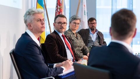 Panelisten im Gespräch Teilnehmende sitzen zusammen und unterhalten sich