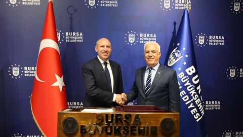 Europaminister Pentz schüttelt Hand von Bürgermeister von Bursa. Im Hintergrund befinden sich die Flaggen der Türkei und der Region Bursa