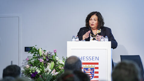 Europastaatssekretärin Karin Müller steht am Podium und hält einen Vortrag