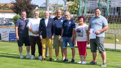 Manfred Pentz posiert gemeinsam mit Mitgliedern des Sportvereins 1919 e.V. Münster auf Sportrasen